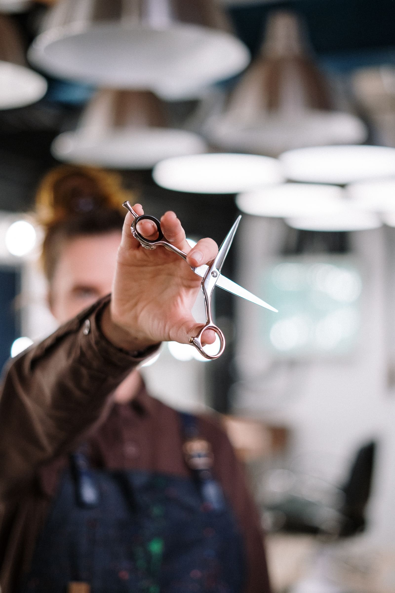 Coiffeur à Saint-Chély-d'Apcher (48200) : trouver le bon salon et un rendez-vous rapide Coiffeuse tenant des ciseaux de coiffure dans un salon moderne