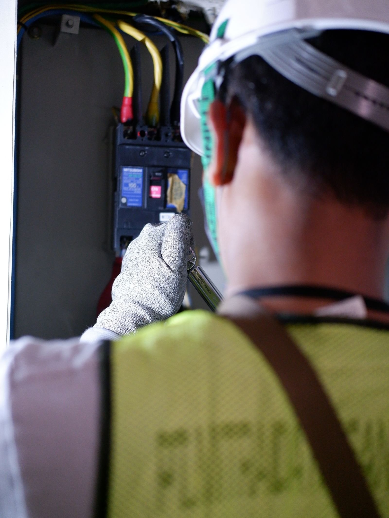 Électricien à Saint-Chély-d'Apcher (48200) : trouver un professionnel qualifié Electricien portant des gants travaillant sur un disjoncteur en interieur