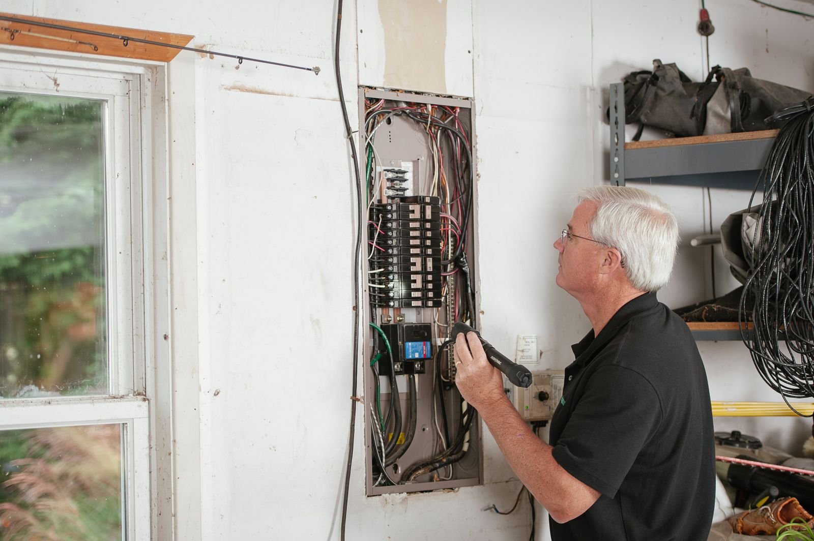 Électricien à Saint-Chély-d'Apcher (48200) : trouver un professionnel qualifié Electricien inspectant un tableau electrique residentiel