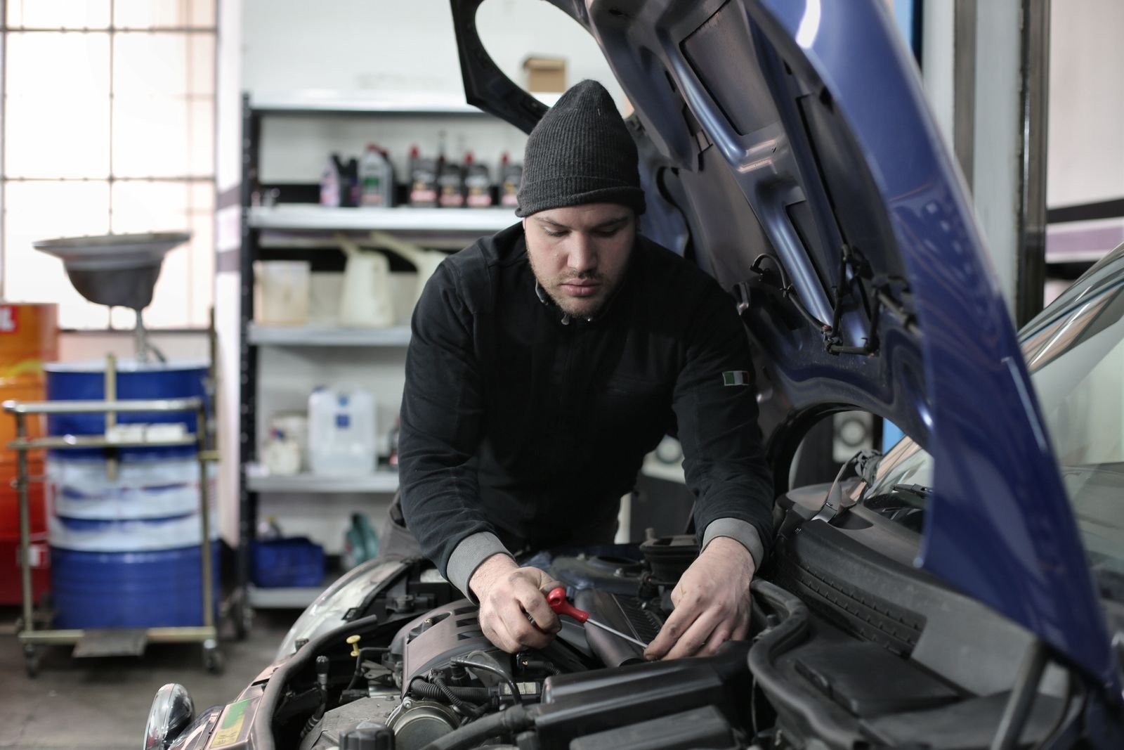 Garagiste à Saint-Chély-d’Apcher (48200) : la voiture qui ne peut pas attendre Mecanicien travaillant sous le capot d-une voiture dans un garage