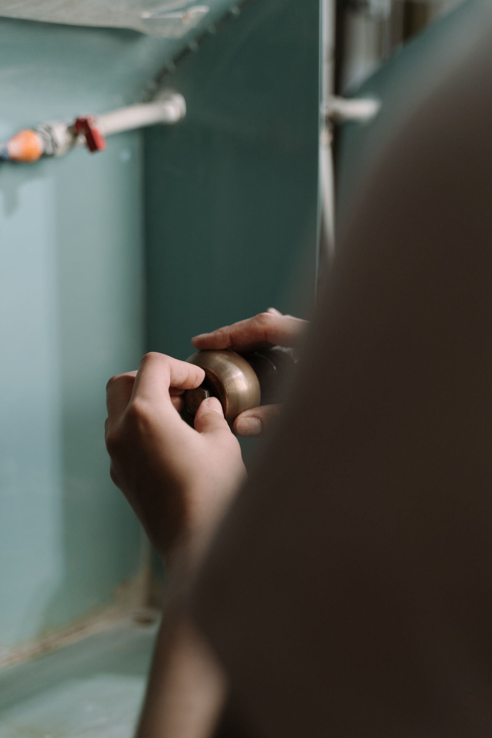 Plombier intervenant sous un evier de cuisine chez un particulier